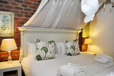 a bedroom with a white bed with a canopy at Los Olivos at the Yard in Franschhoek
