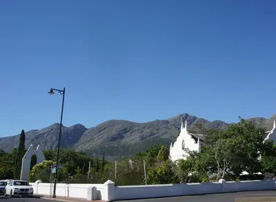 a white church with mountains in the background at 5 Pierre Jourdan in Franschhoek