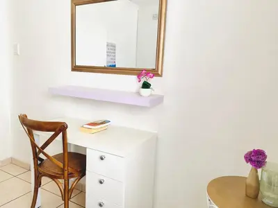 a desk with a chair and a mirror and a table at Villa V in Cape Town