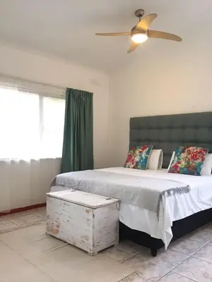 a bedroom with two beds and a ceiling fan at Villa V in Cape Town