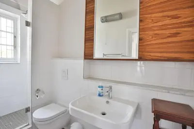 a bathroom with a sink and a toilet and a mirror at Laanhof Victorian House Self-Catering in Stellenbosch