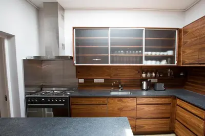 a kitchen with wooden cabinets and a sink and a stove at Laanhof Victorian House Self-Catering in Stellenbosch