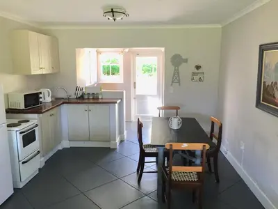 a kitchen with a table and chairs and a kitchen with a stove at Olive Cottage in Franschhoek