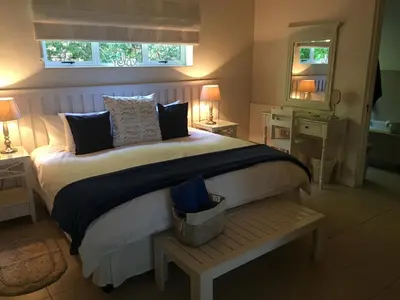 a bedroom with a large bed and a window at The Blue Marine Self-Catering in Gordonʼs Bay