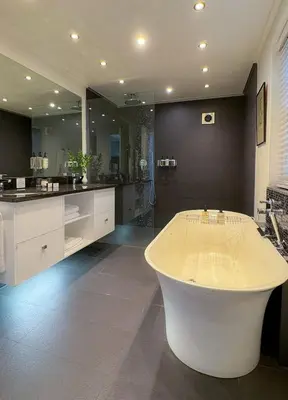 a large bathroom with a tub and a large mirror at Grande Roche Hotel in Paarl