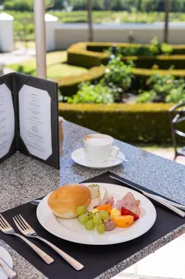 a plate of food with a bagel and vegetables on a table at Grande Roche Hotel in Paarl