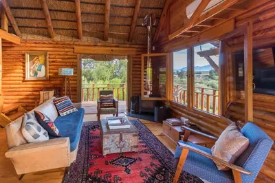 a living room with a couch and a table in a cabin at Tulbagh Mountain Cabin in Wolseley