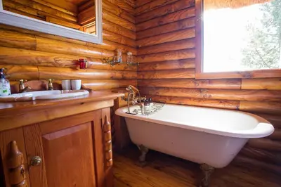 a bathroom with a tub and a sink and a window at Tulbagh Mountain Cabin in Wolseley