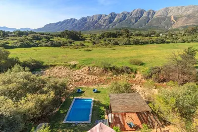 an overhead view of a pool in a field with mountains at Tulbagh Mountain Cabin in Wolseley