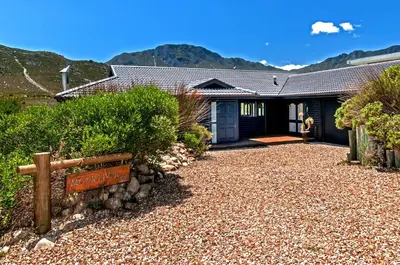 a house with a sign in front of it at Moon River House in Pringle Bay
