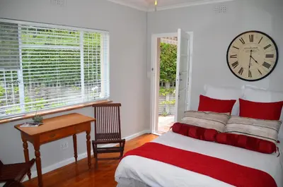 a bedroom with a clock on the wall and a bed at Anni Bos in Stellenbosch