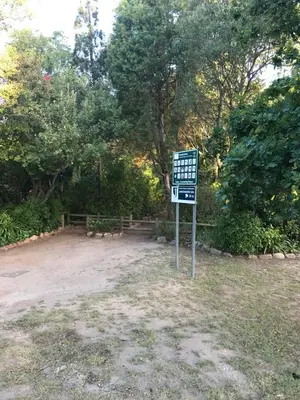 a sign in the middle of a park with trees at At Home in Mostertsdrift in Stellenbosch