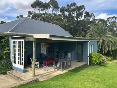 a blue cottage with a porch and a patio at Shabach Farm in Hartebeest Rivier