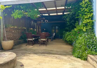 a patio with chairs and a table in a building at Shabach Farm in Hartebeest Rivier