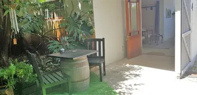 a table and a bench in a room with plants at Hemel en Aarde Village Accommodation in Hermanus