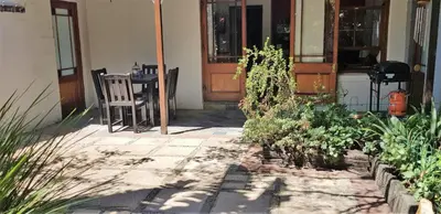 a porch of a house with a table and chairs at Hemel en Aarde Village Accommodation in Hermanus