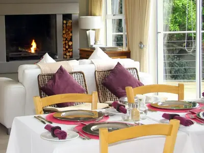 a dining room with a white table with purple pillows at Eversview Guesthouse in Durbanville