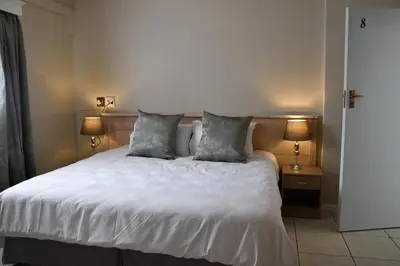 a bedroom with a white bed with two pillows at 34onlincoln Guesthouse in Bellville