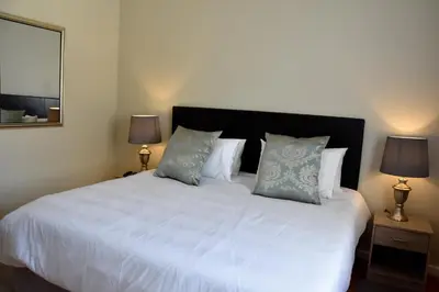 a bedroom with a large white bed with two lamps at 34onlincoln Guesthouse in Bellville