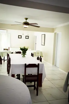 a dining room with a white table and chairs at 34onlincoln Guesthouse in Bellville