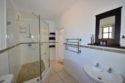 a bathroom with a glass shower and a sink at Acara Guesthouse & Cottages in Stellenbosch