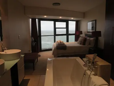 a bathroom with a sink and a bed and a tub at Ocean View 905 Self Catering Accommodation Strand Western Cape South Africa in Strand