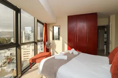 a bedroom with a bed and a large window at Ocean View 905 Self Catering Accommodation Strand Western Cape South Africa in Strand