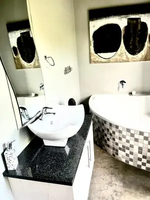 a bathroom with a sink and a bath tub and a sink at 3 Indigo with Solar in Hermanus