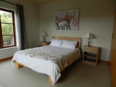 a bedroom with a large bed and a window at Sunset at Diluta in Cape Town
