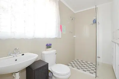 a bathroom with a toilet and a sink and a shower at Arum Field Accommodation in Table View