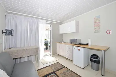 a kitchen with a couch and a table in a room at Arum Field Accommodation in Table View
