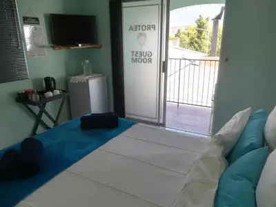 a room with a bed and a television and a balcony at Mountainia Inn in Worcester