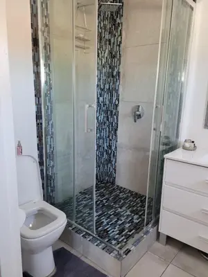 a bathroom with a shower with a toilet and a sink at 109 da Gama on Beach in Strand