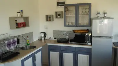 a kitchen with a refrigerator and a sink at 29 Carissa Street in Somerset West