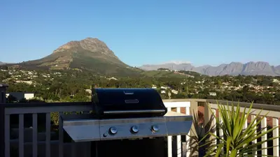 a grill on a balcony with mountains in the background at 29 Carissa Street in Somerset West