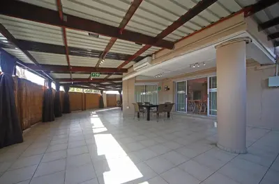 a large empty room with a table and chairs at Savoy Lodge in Cape Town