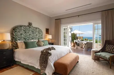 a bedroom with a bed with a cat laying on it at La Fontaine Guest House Hermanus in Hermanus