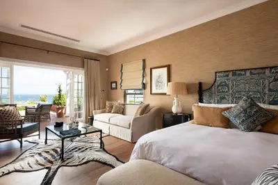a bedroom with a bed and a living room at La Fontaine Guest House Hermanus in Hermanus