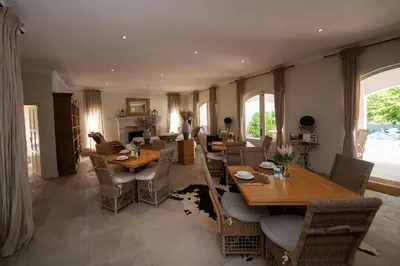 a living room with wooden tables and chairs at Maison d'Ail Guest House in Franschhoek