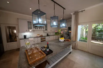 a kitchen with a counter with wine glasses on it at Maison d'Ail Guest House in Franschhoek