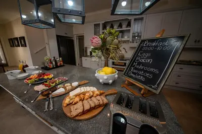 a kitchen counter with a table with food on it at Maison d'Ail Guest House in Franschhoek