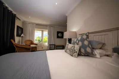 a bedroom with a bed with pillows and a window at Maison d'Ail Guest House in Franschhoek