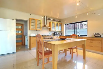 a kitchen with a table and chairs and a refrigerator at Sunset at Granula in Cape Town