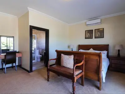 a bedroom with a bed and a desk and a chair at Kwantu Guesthouse 2 in Cape Town