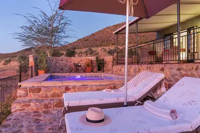 a patio with an umbrella and a swimming pool at Olive Hill Guest House in Robertson