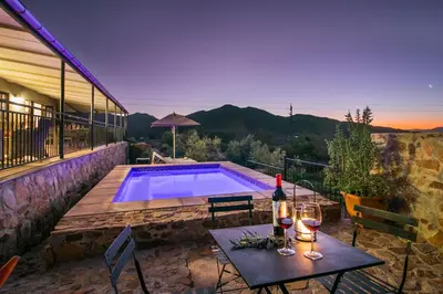a patio with a table with wine glasses and a pool at Olive Hill Guest House in Robertson