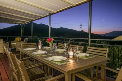 a table on a deck with a view of the mountains at Olive Hill Guest House in Robertson
