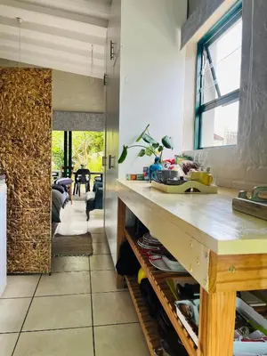 a kitchen with a counter and a table in a room at Lemontree in Hermanus