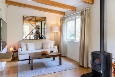 a living room with a white couch and a wood stove at Angala in Simondium