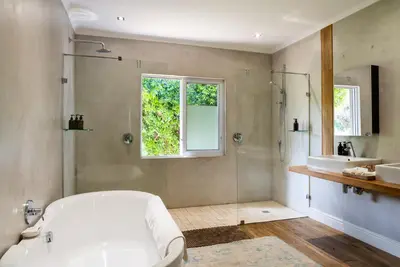a bathroom with a tub and a shower and a sink at Angala in Simondium
